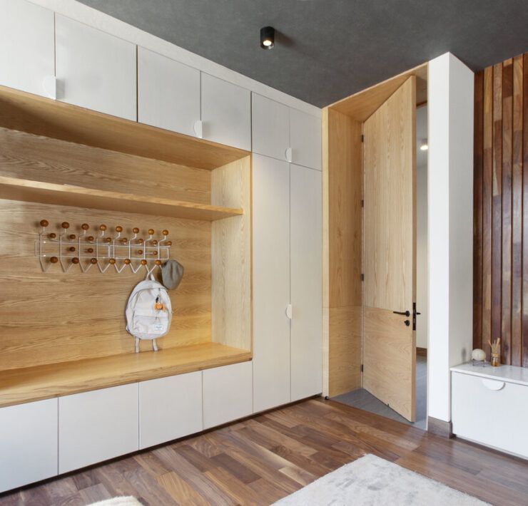 Estancia de Casa Ficus con mueble blanco, nicho de madera y muro de madera