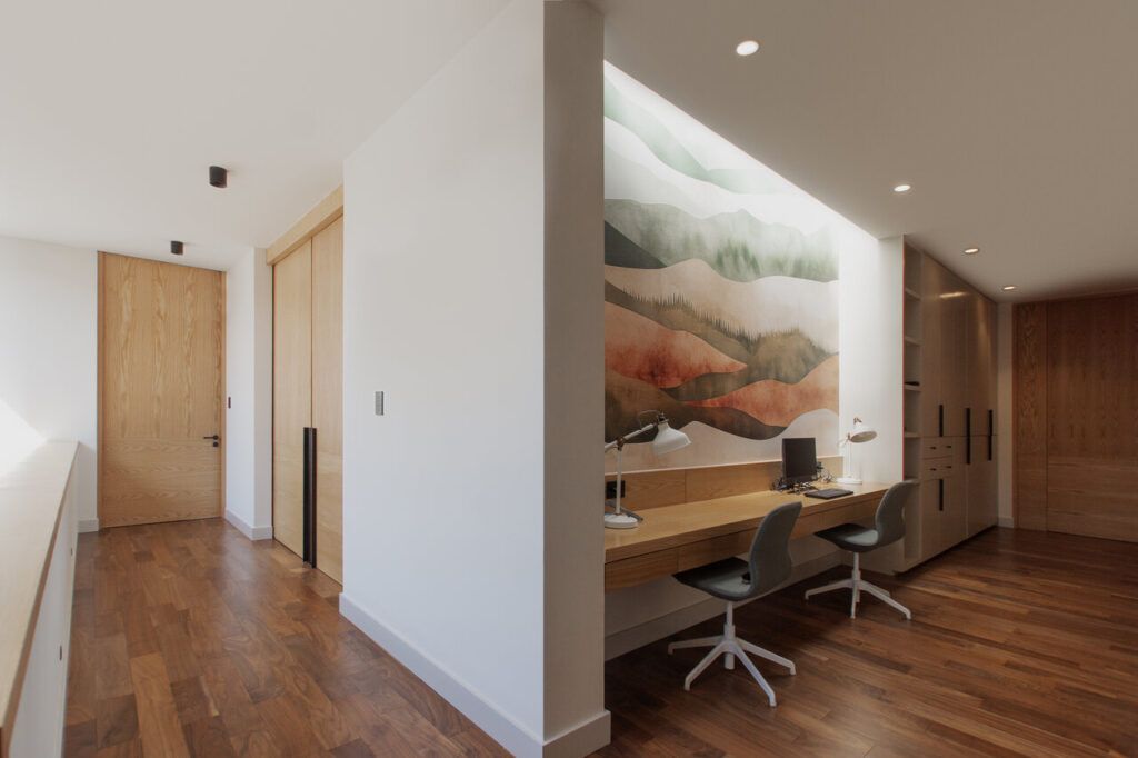 Pasillo de Casa Ficus con estudio integrado y mural de paisaje
