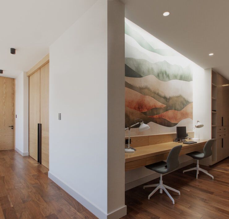 Pasillo de Casa Ficus con estudio integrado y mural de paisaje