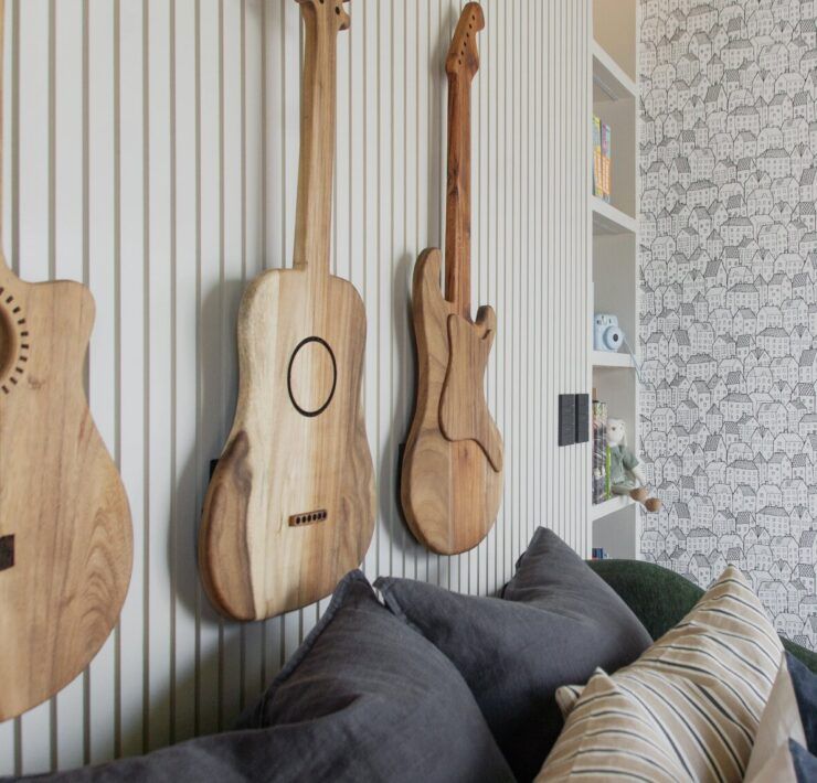 Sala de Casa Ficus con guitarras de madera como decoración en el muro