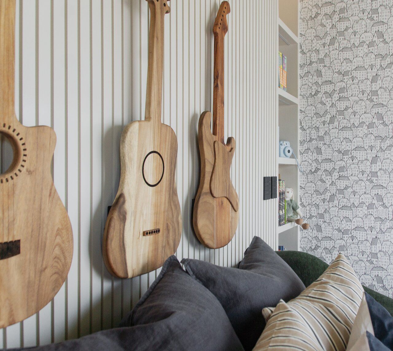 Sala de Casa Ficus con guitarras de madera como decoración en el muro