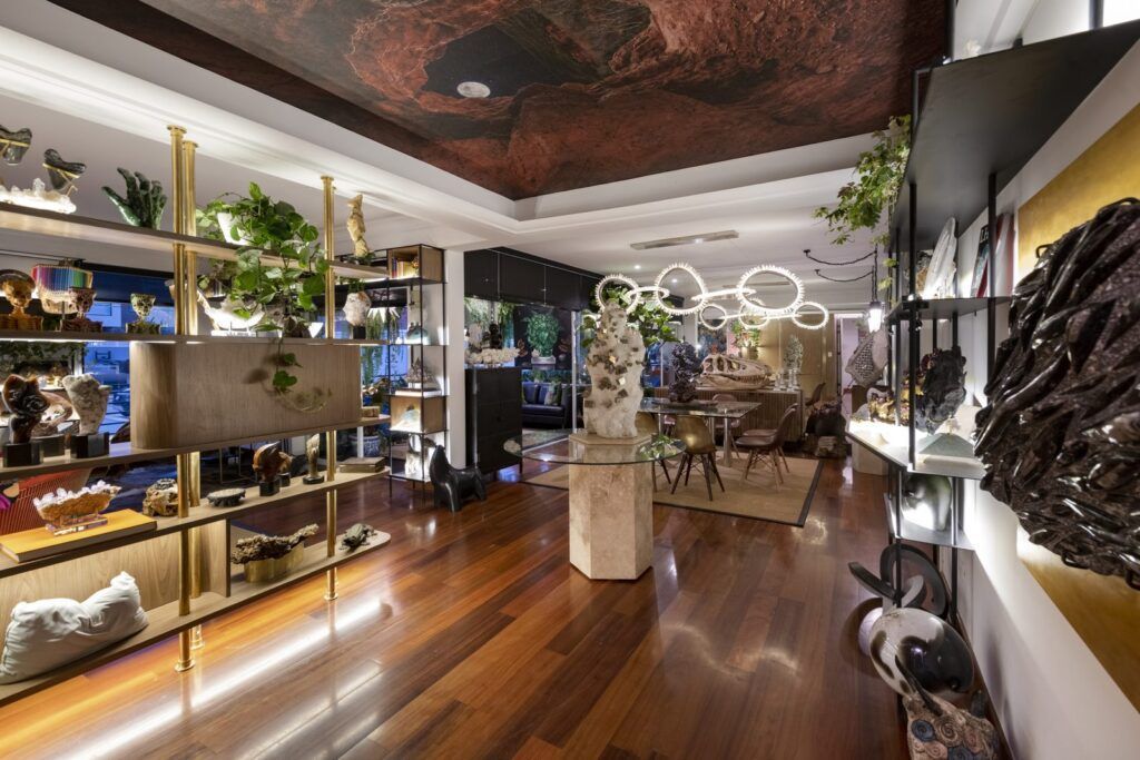 Vista del ingreso de Casa Mineral hacia el comedor, con plafón que simula roca, repisas de bronce y piso de madera