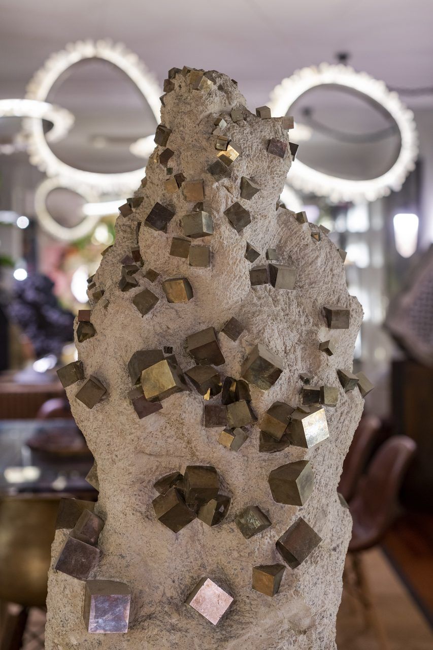 Cristales cúbicos de pirita sobre roca matriz exhibidos en Casa Mineral