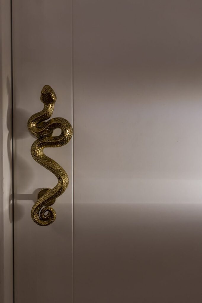 Jaladera de bronce en forma de serpiente en la puerta principal de Casa Mineral