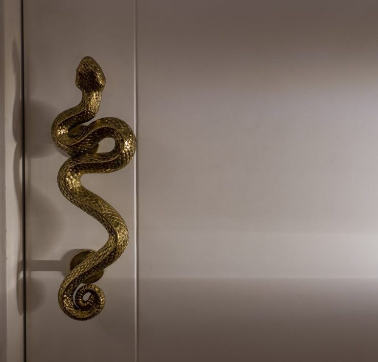 Jaladera de bronce en forma de serpiente en la puerta principal de Casa Mineral