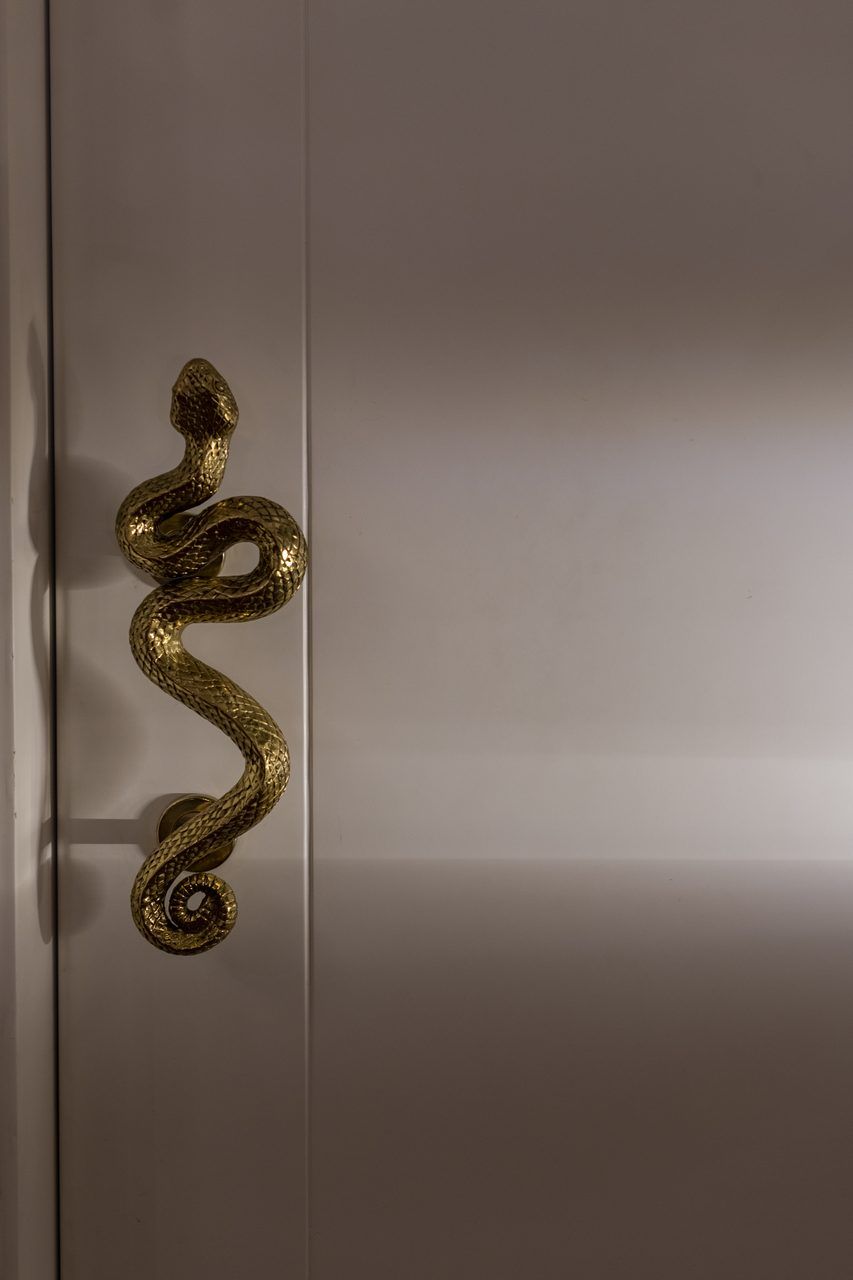 Jaladera de bronce en forma de serpiente en la puerta principal de Casa Mineral