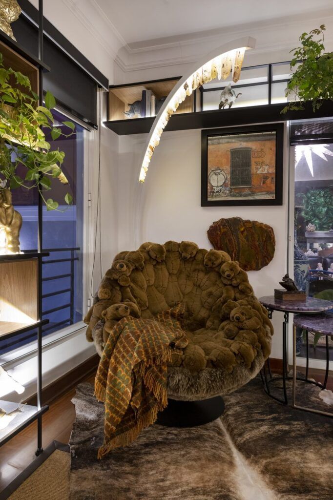 Rincón de lectura de Casa Mineral con sillón cubierto de osos de peluche, tapete de piel y lámpara de arco