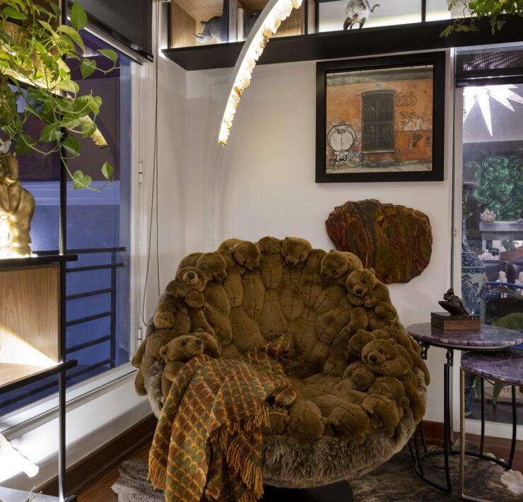 Rincón de lectura de Casa Mineral con sillón cubierto de osos de peluche, tapete de piel y lámpara de arco