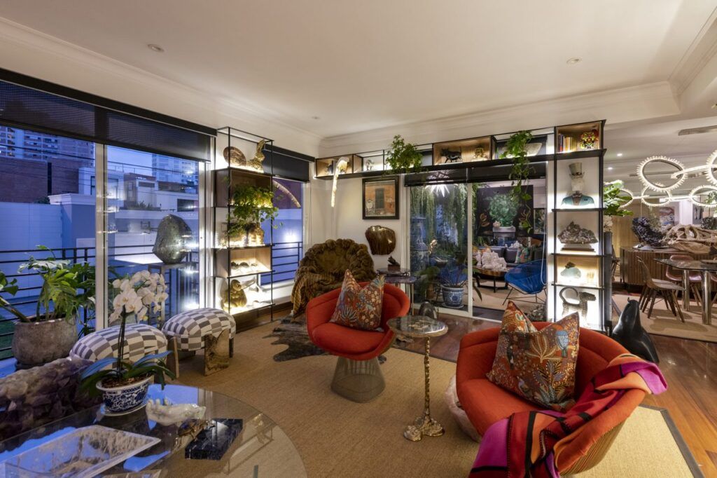 diseño de interiores en Lima de Casa Mineral hacia la terraza y el comedor, con otomanas a cuadros y sillones rojos