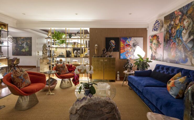 Sala de Casa Mineral en San Isidro, Lima, con sillones rojos estilo Warren Platner, sofá azul y mesa de centro de amatista
