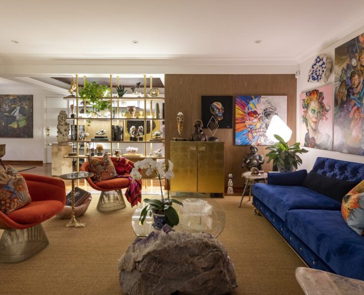 Sala de Casa Mineral en San Isidro, Lima, con sillones rojos estilo Warren Platner, sofá azul y mesa de centro de amatista
