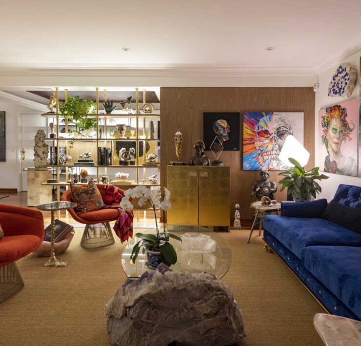 Sala de Casa Mineral en San Isidro, Lima, con sillones rojos estilo Warren Platner, sofá azul y mesa de centro de amatista