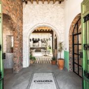 Pasillo con arcos de piedra en Casona Obregón 55, con vista hacia el bar del fondo