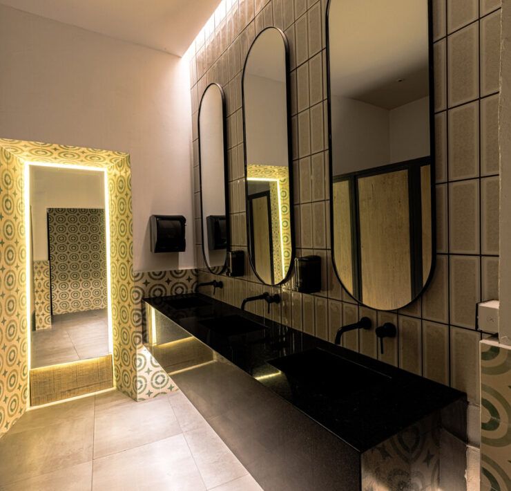 Baño de Casona Obregón 55 con espejos dorados y tocador en tonos cálidos