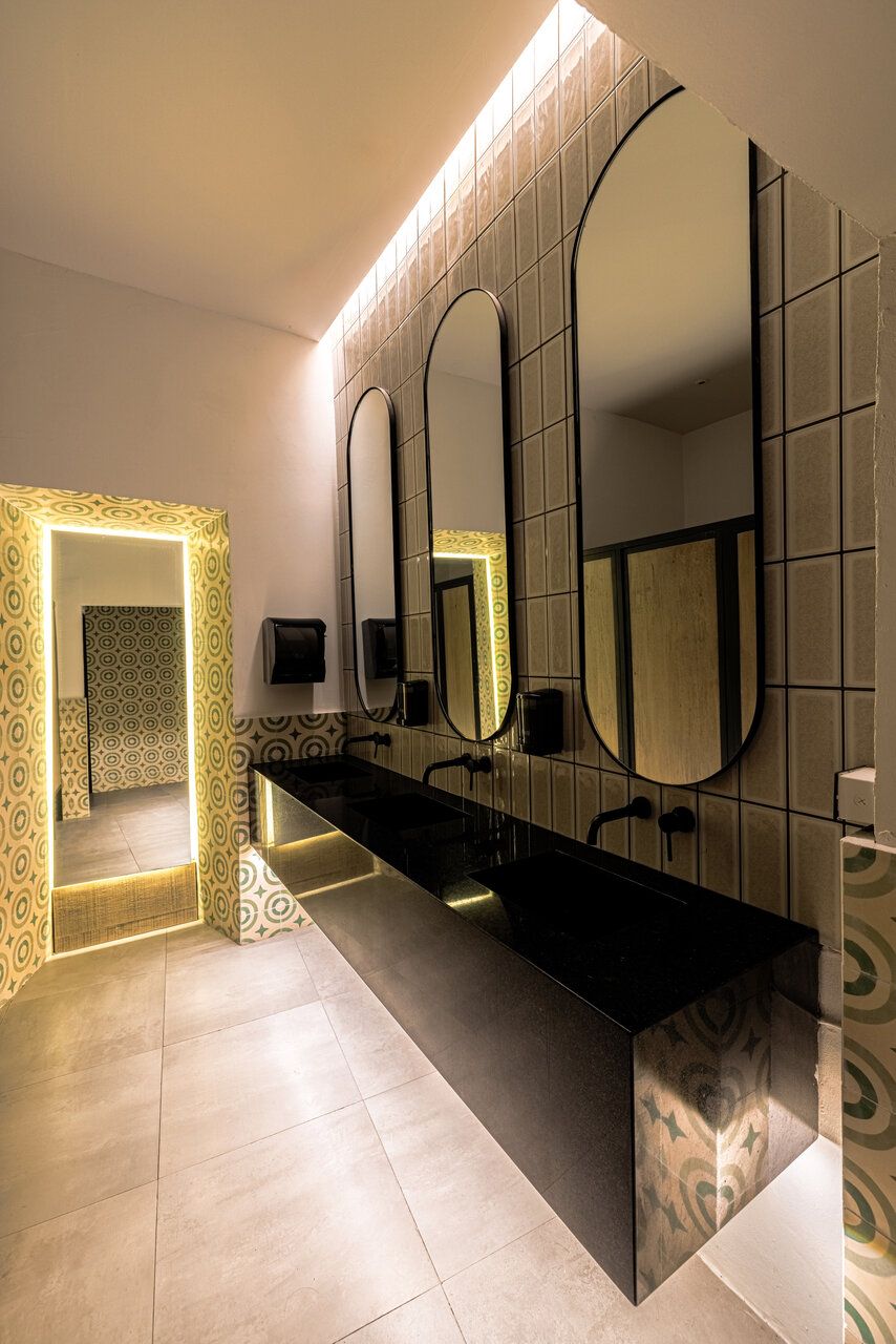 Baño de Casona Obregón 55 con espejos dorados y tocador en tonos cálidos