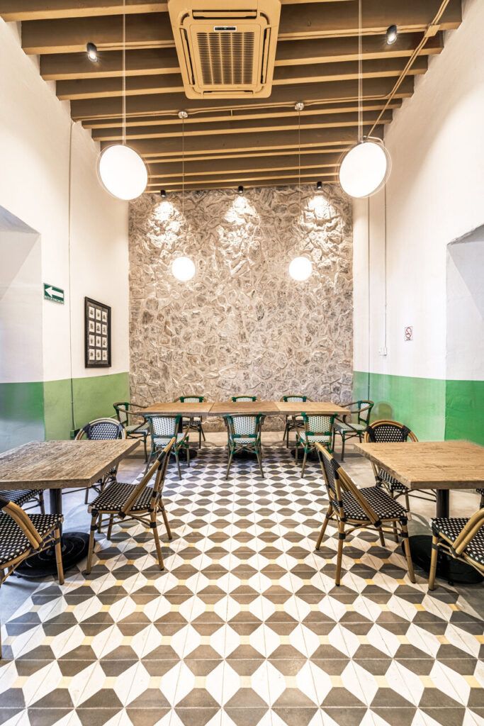 Salón interior de Casona Obregón 55, restaurante en el centro de Hermosillo con muro de piedra original y mobiliario contemporáneo