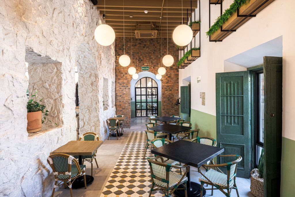Comensales en salón de Casona Obregón 55 junto a muro de piedra y techo de madera