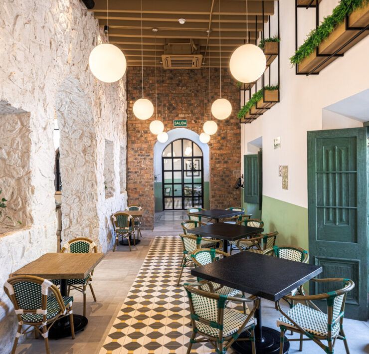 Comensales en salón de Casona Obregón 55 junto a muro de piedra y techo de madera