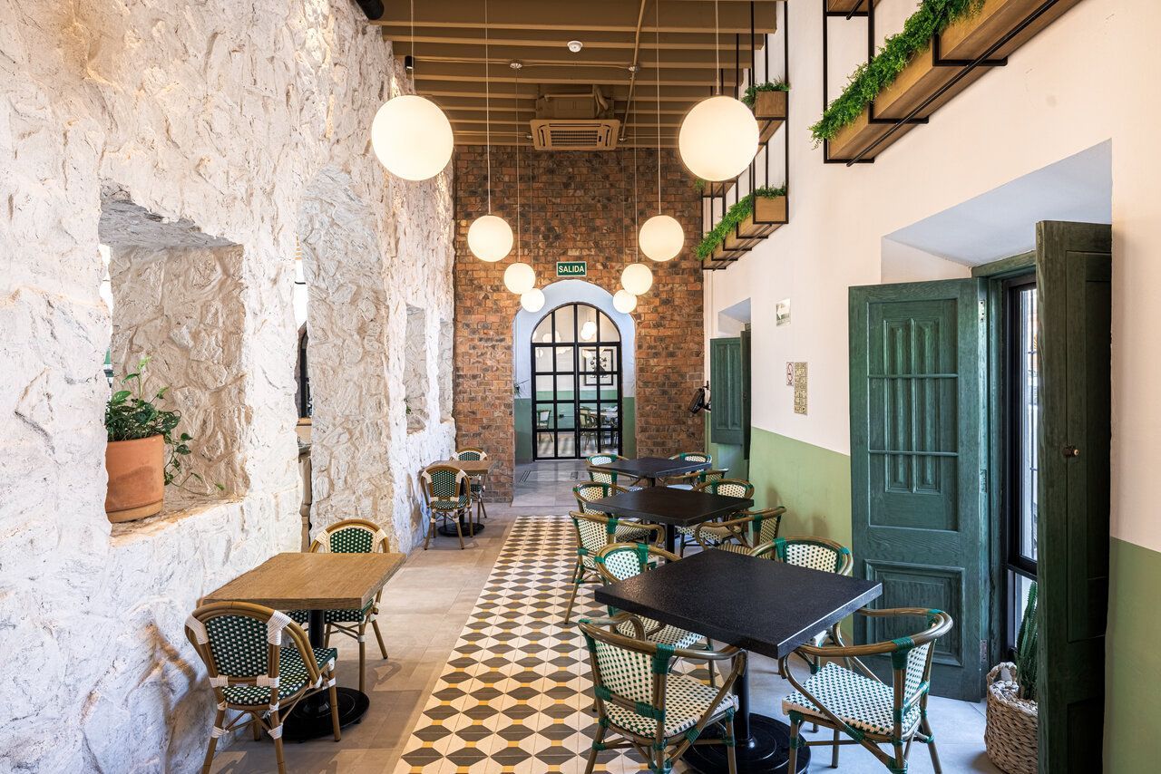 Comensales en salón de Casona Obregón 55 junto a muro de piedra y techo de madera