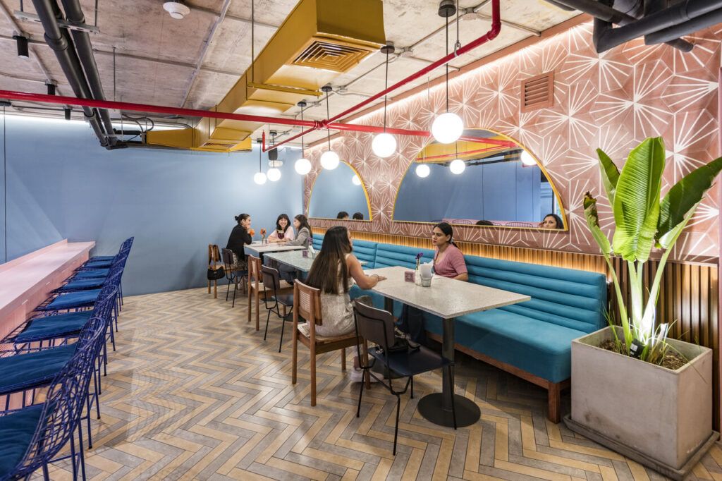 Comedor de Checha Tea Bar con banca azul y plantas colgantes