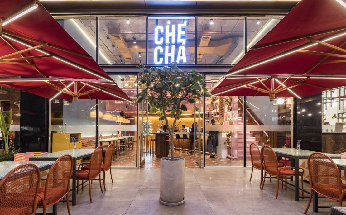 Entrada de Checha Tea Bar & Food Station, un restaurante tematico en LIma de Lee Arquitectos, con letrero de neón y toldos rojos