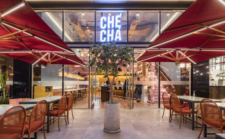 Entrada de Checha Tea Bar & Food Station, un restaurante tematico en LIma de Lee Arquitectos, con letrero de neón y toldos rojos