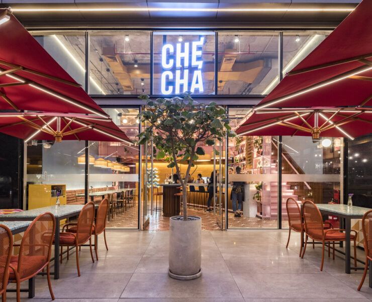 Entrada de Checha Tea Bar & Food Station, un restaurante tematico en LIma de Lee Arquitectos, con letrero de neón y toldos rojos