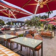 Terraza exterior de Checha Tea Bar con sombrillas rojas sobre la calle