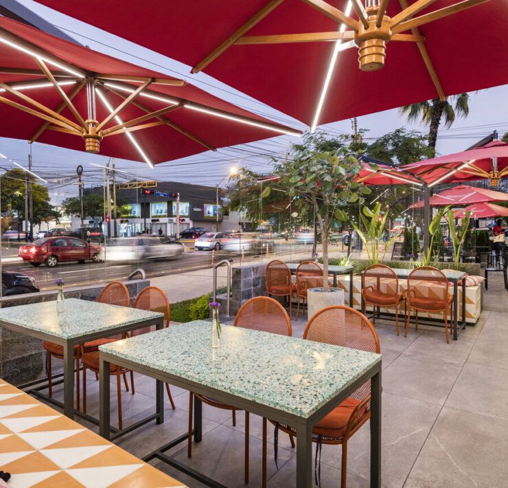 Terraza exterior de Checha Tea Bar con sombrillas rojas sobre la calle